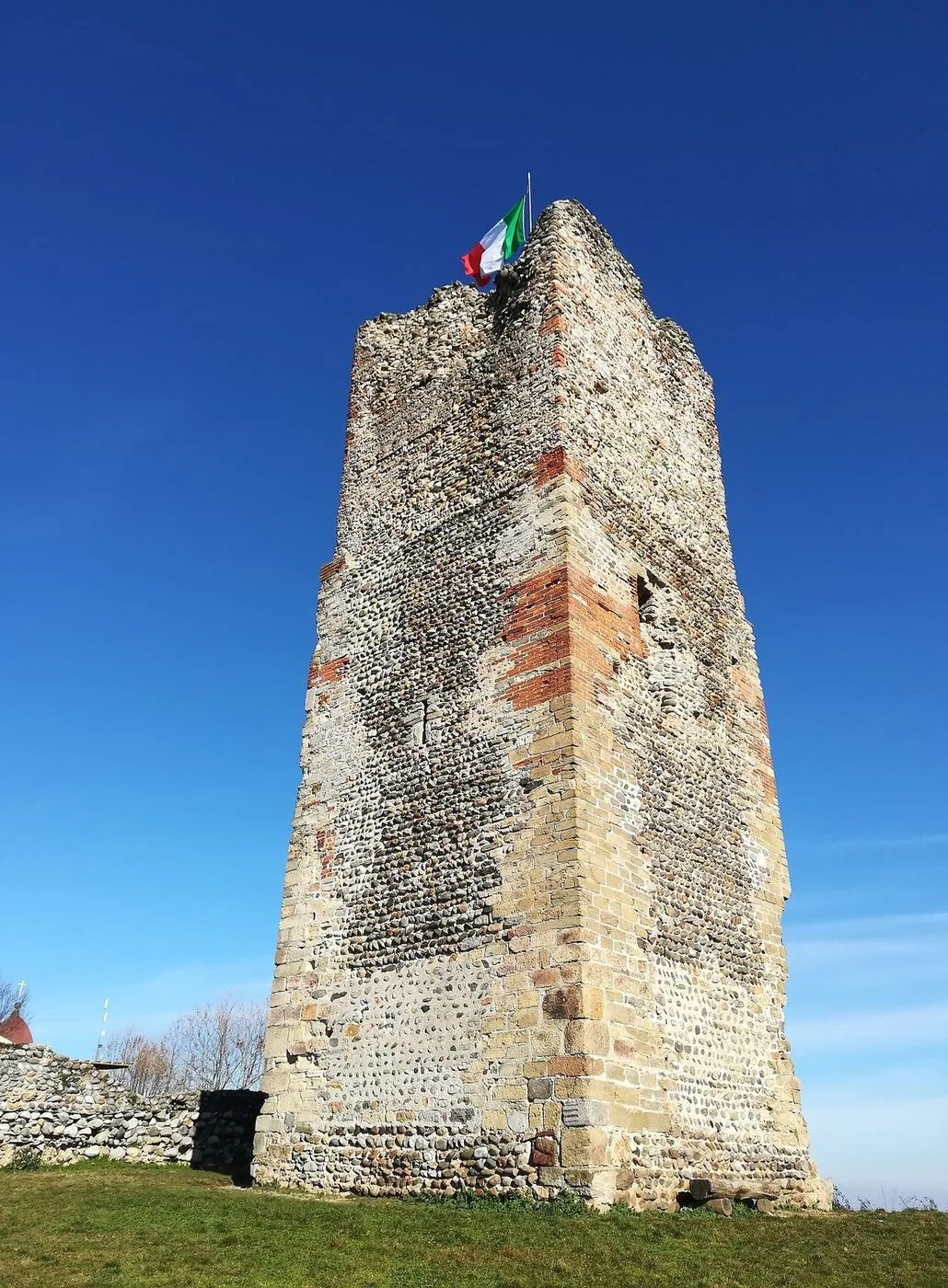 La Torre delle Castelle a Gattinara, rudere in pietra su un prato con cielo azzurro